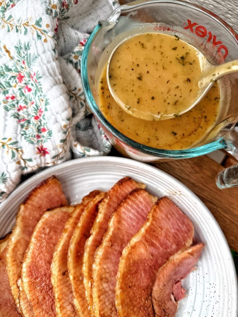Slices of ham next to ham gravy