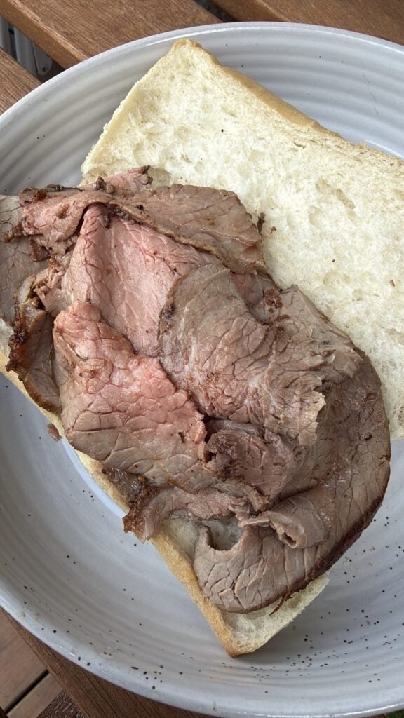 Sliced, cooked beef on the open bun