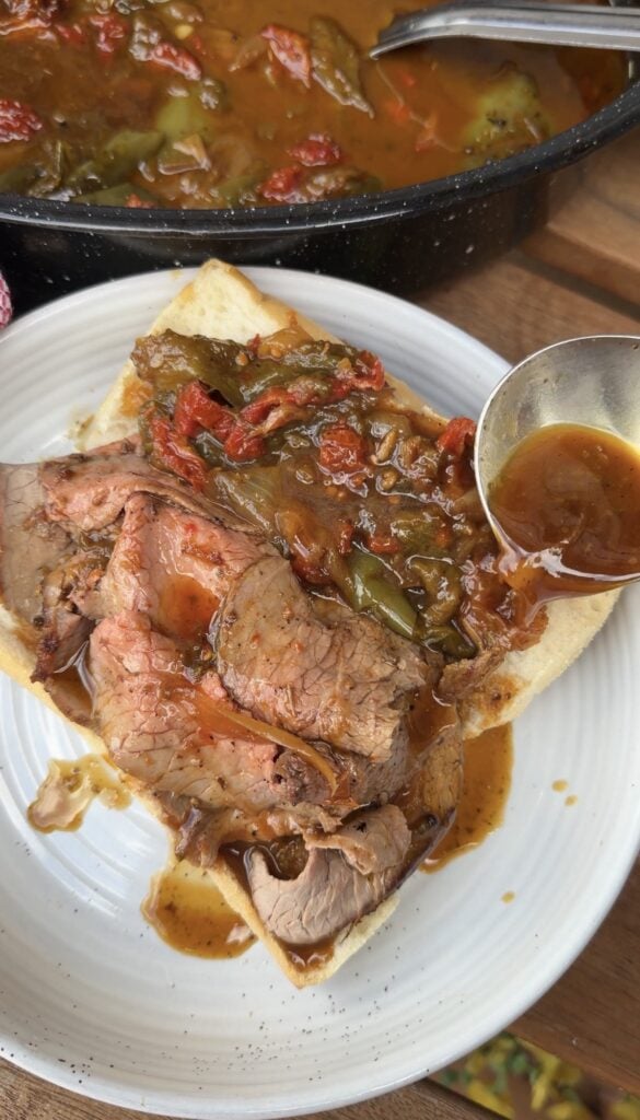 Au jus being labeled over the finished sandwich