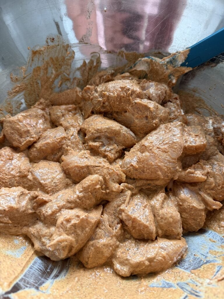 The chicken coated with spices and yogurt before being cooked