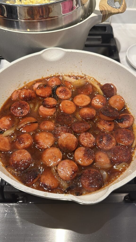 The sausage slices in the pan after the sauce is added