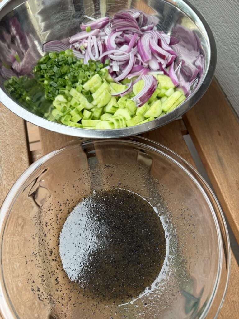 The bowl of cut up veggies and the bowl of vinaigrette