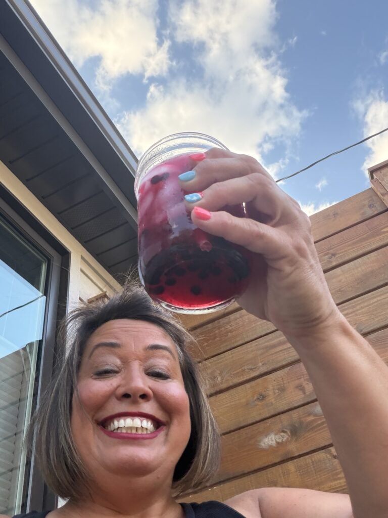 Tipsy holding the cocktail in a jar outside