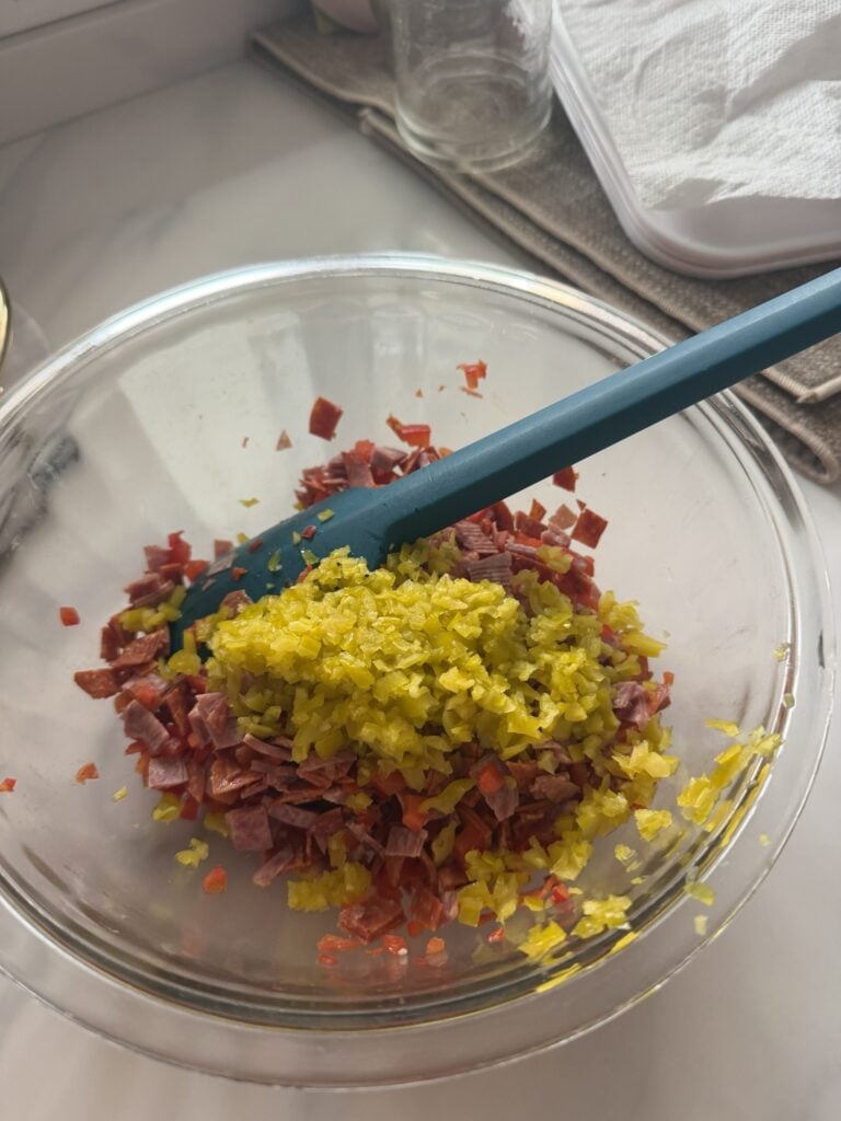 The chopped peppers and meat being mixed in the bowl