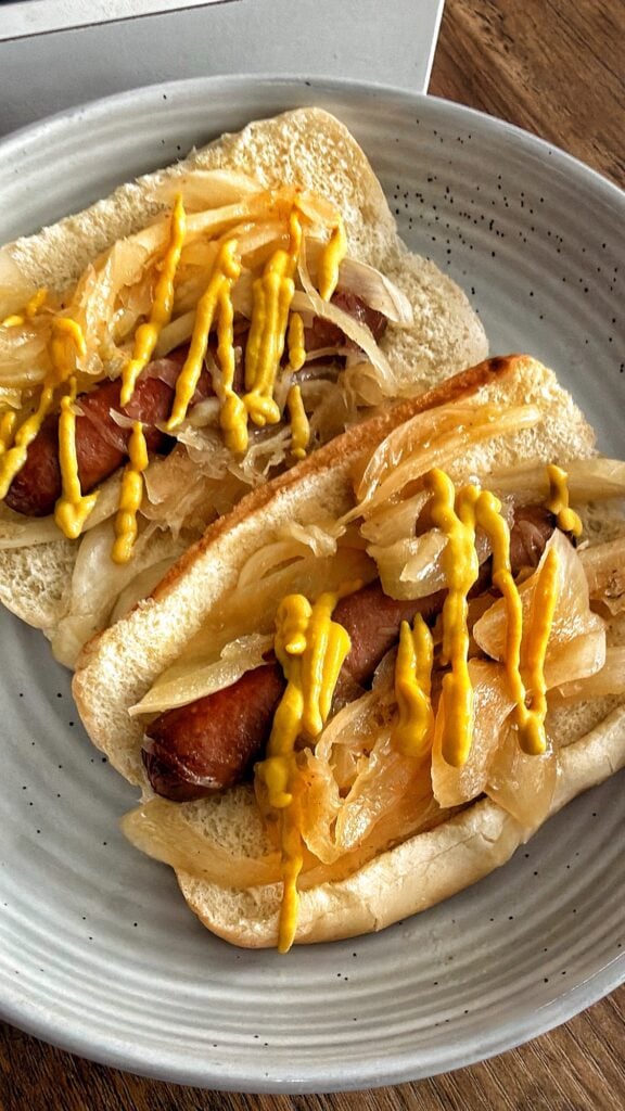 Crockpot New York Style Hot Dogs topped with onions and mustard