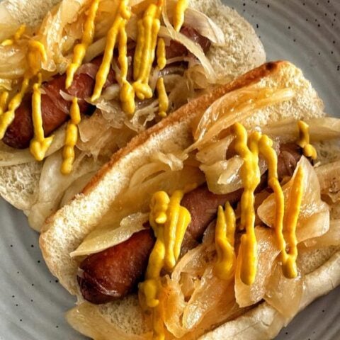 Crockpot New York Style Hot Dogs topped with onions and mustard