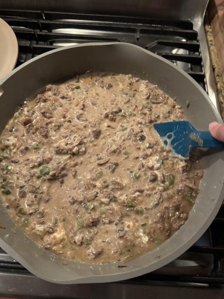 The sauce with meat and vegetables simmering in the pan