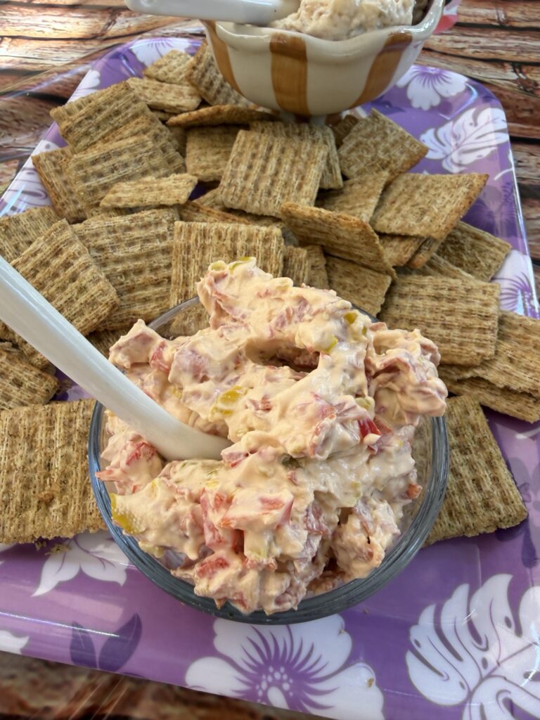 The dip with a spoon in it surrounded by crackers