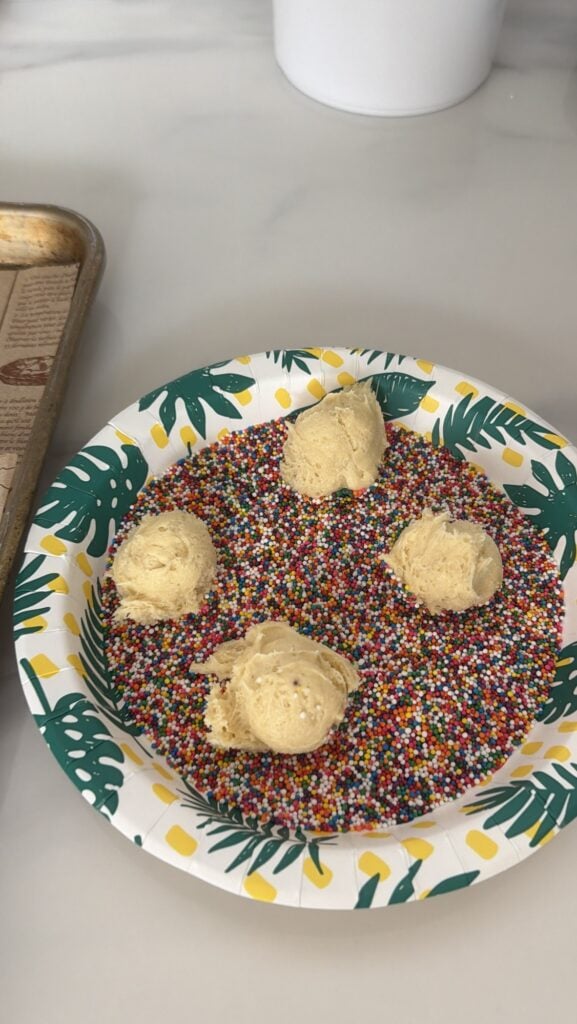 Balls of dough in a bowl of nonpareils