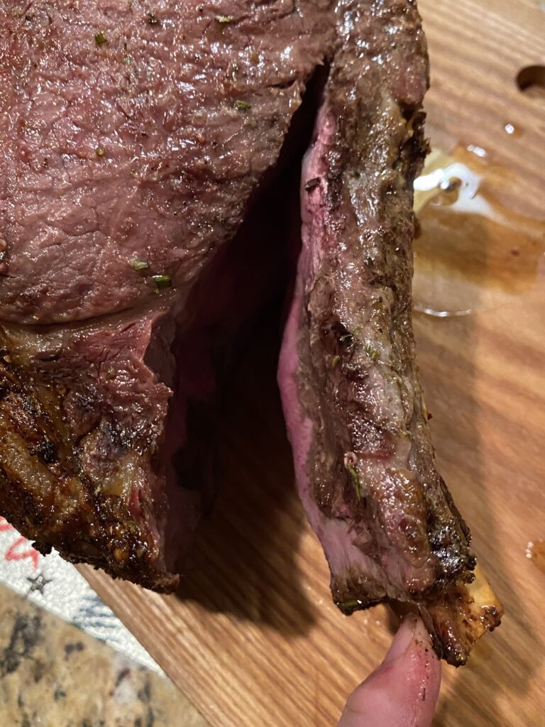 Removing the rib bones from a cooked standing rib roast before slicing.