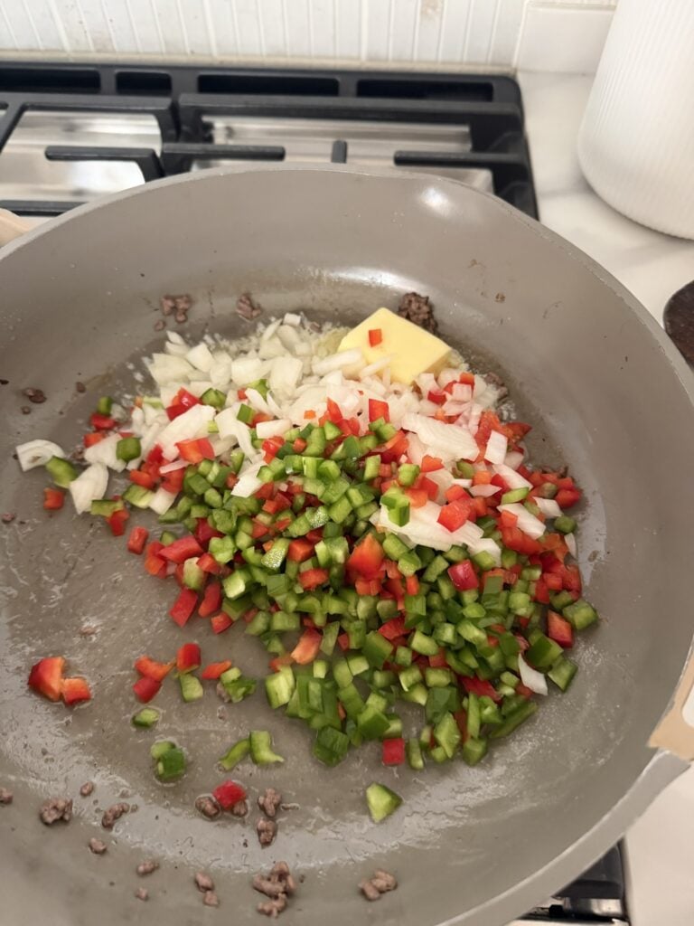Diced veggies and butter cooking in the pan