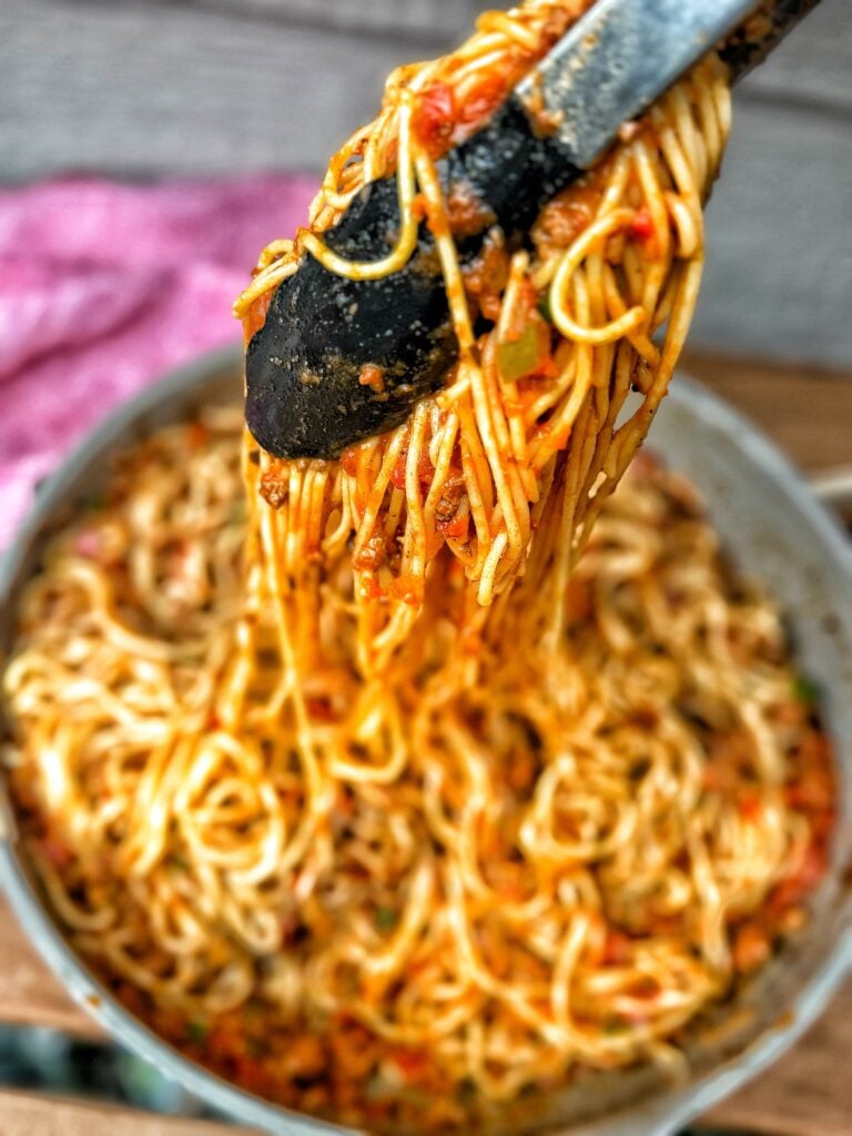 Tongs grabbing the Cajun spaghetti