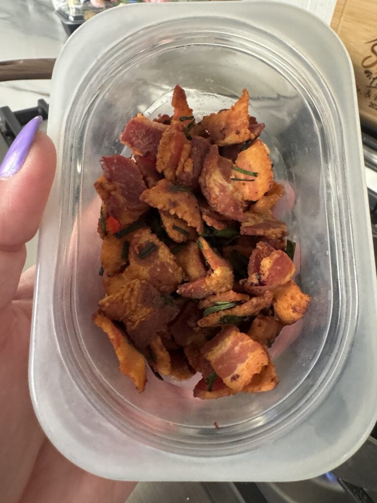 Crispy thick cut bacon pieces in a plastic container