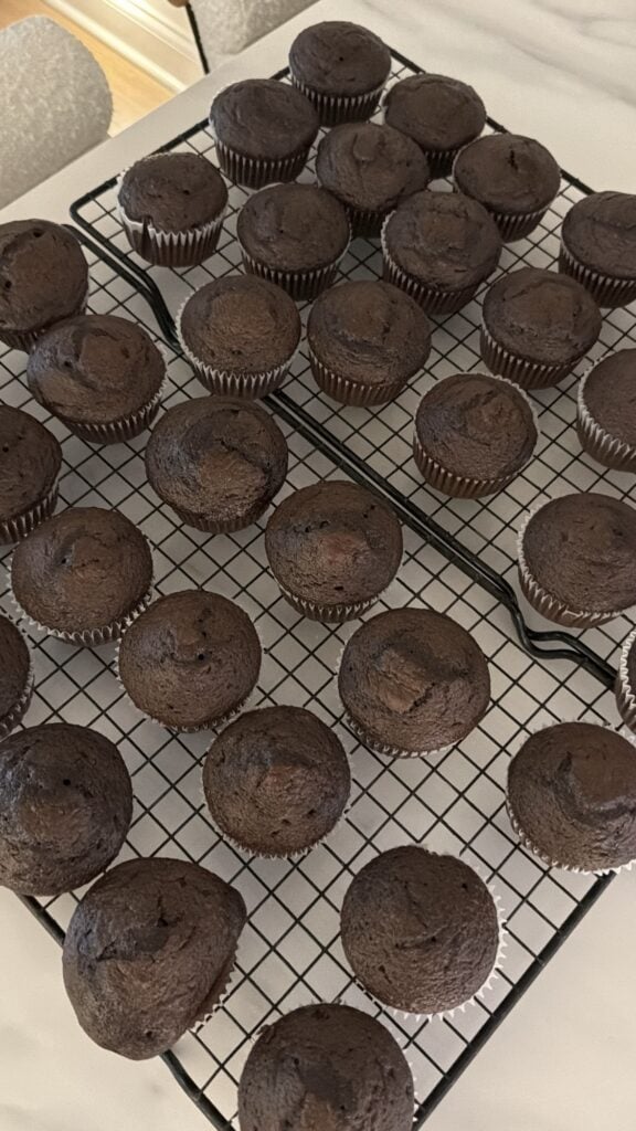 Homemade style chocolate cupcakes cooling completely on wire racks before frosting