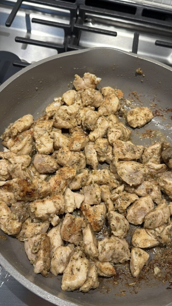 Seasoned chicken pieces browned in butter in a deep skillet