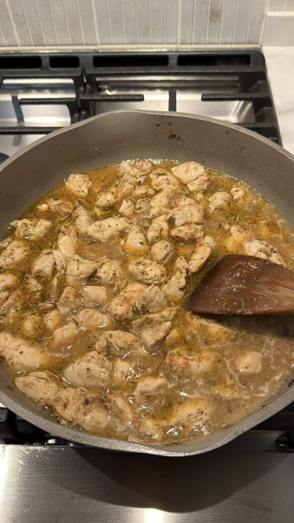 Chicken simmering in tomato and chicken broth