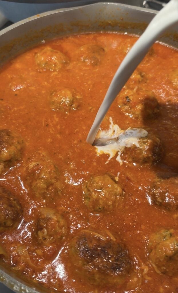 Cream being poured into the meatball mixture