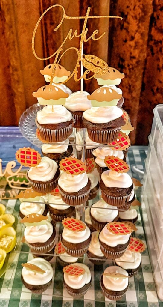 Doctored chocolate cupcakes with fluffy white vanilla frosting on a display for a baby shower