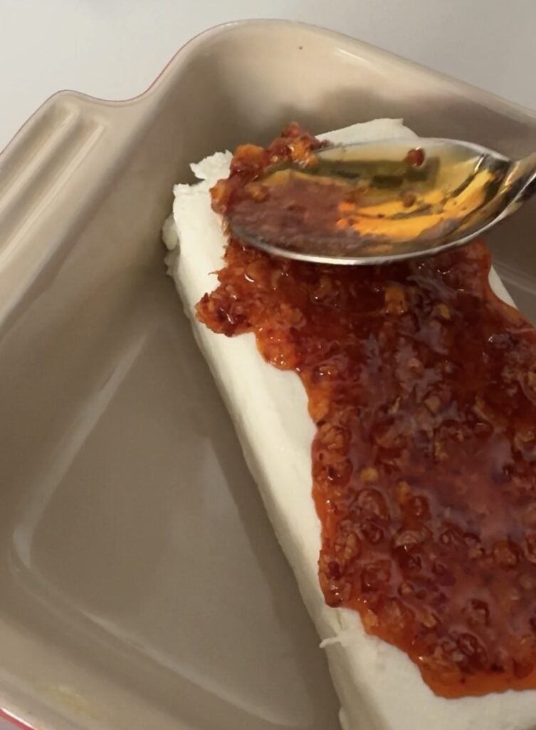 Chili onion crunch spooned over softened cream cheese