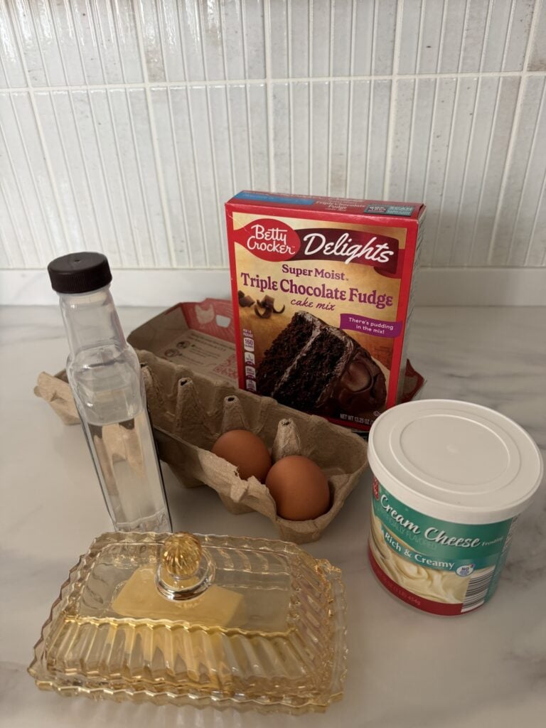 Ingredients for the cupcakes, including boxed chocolate cake mix, butter, eggs, vanilla, and frosting