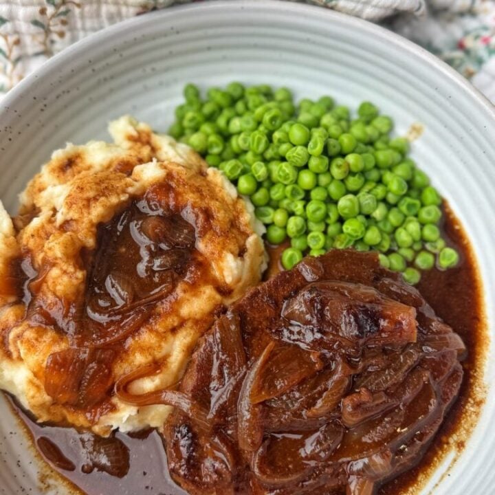 Tender round steak with onion gravy after slow cooking in a skillet