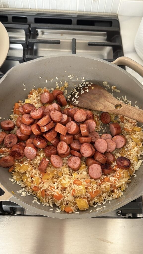 Sausage browning in the skillet with rice