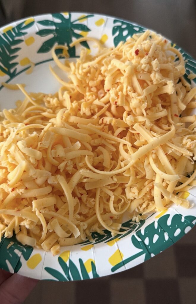 Shredded cheese on a plate that will top the pepper jelly cheese dip