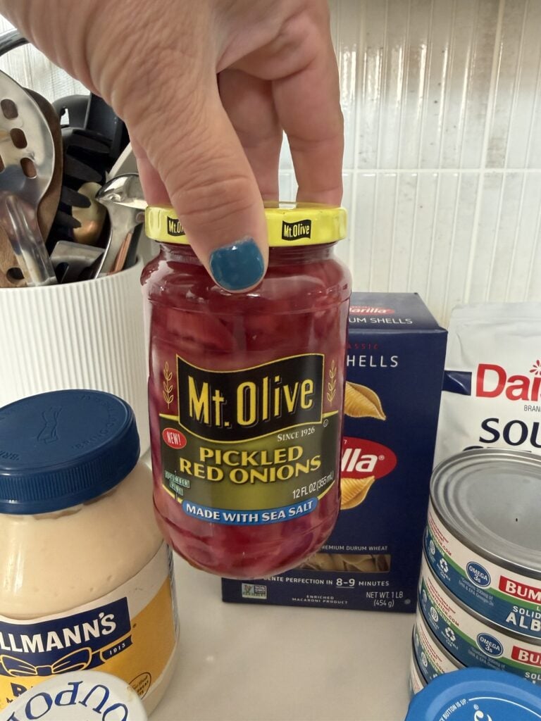Jar of marinated red onions used to make the dressing for tuna pasta salad