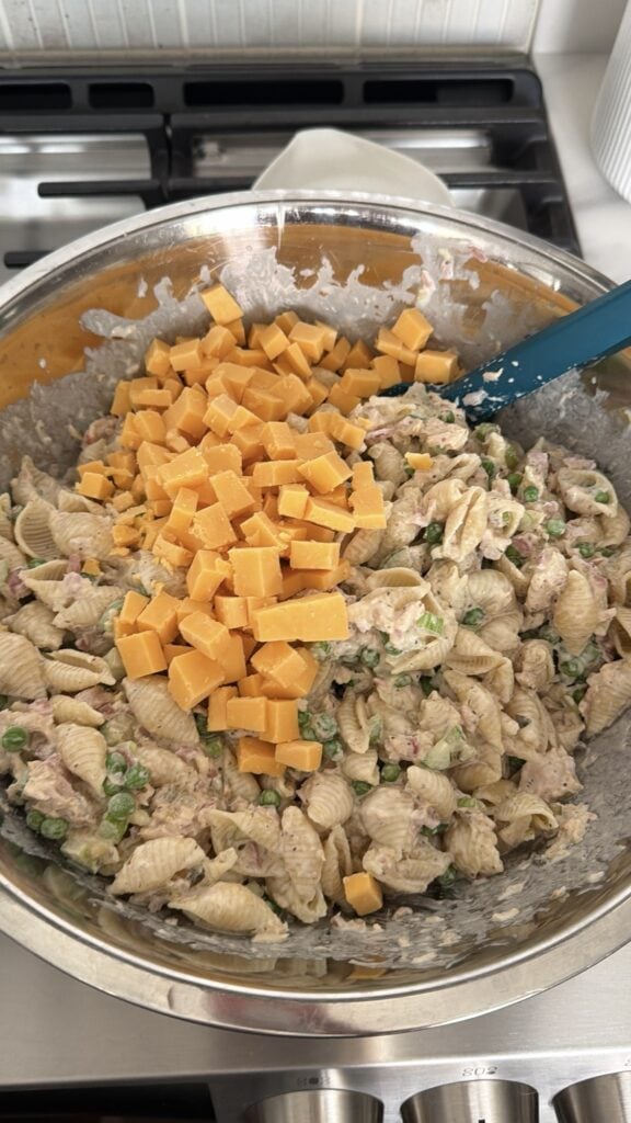 Extra sharp cheddar cheese finely diced on tuna noodle pasta salad