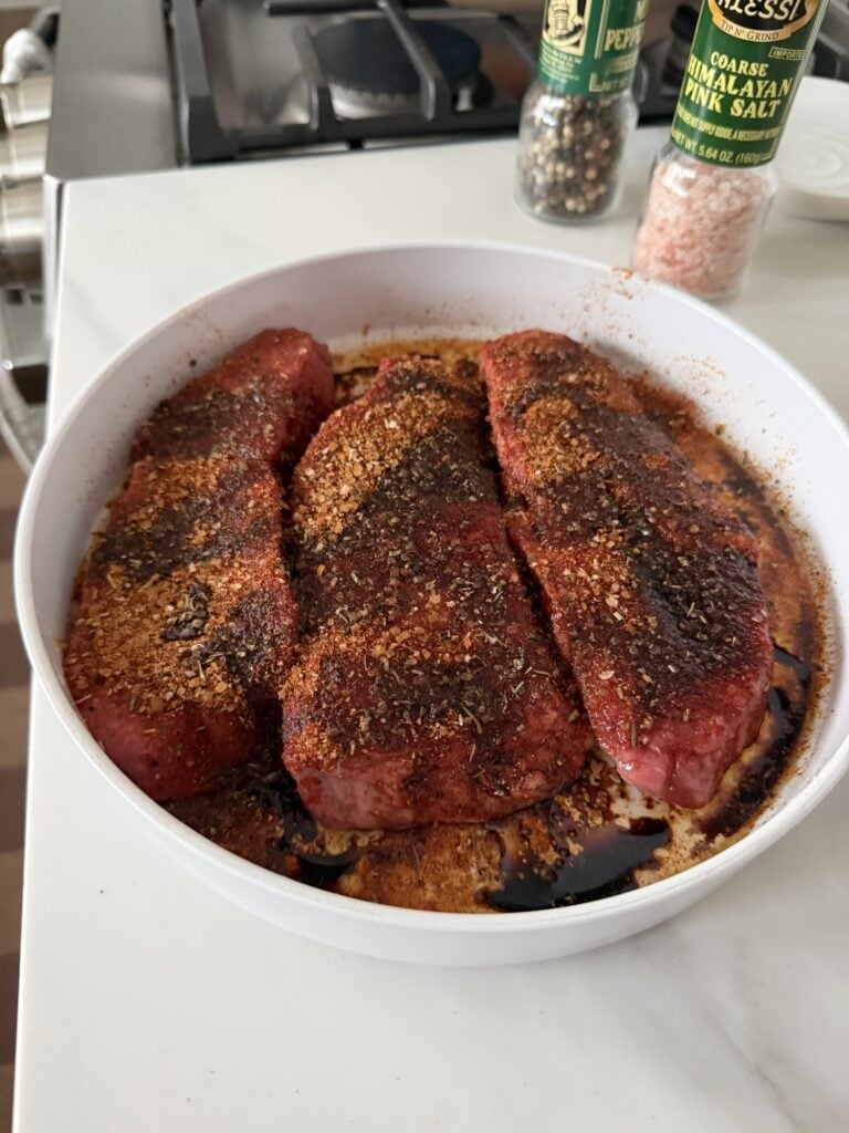 Homemade steak seasoning with coarse salt, black pepper, dried onion, garlic, paprika, oregano, and spices.