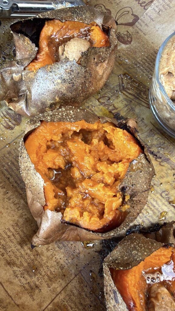 Fluffy baked sweet potato split open and fluffed with a fork
