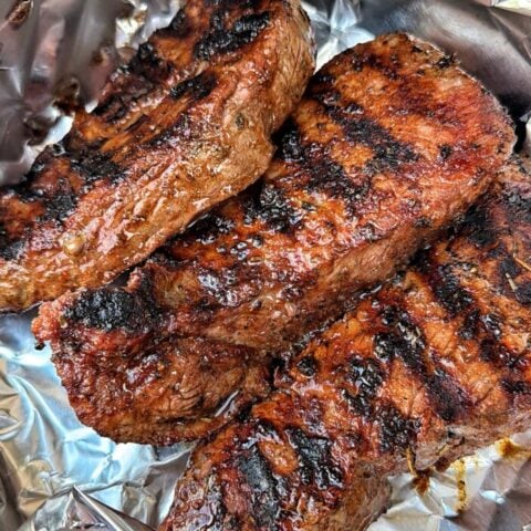 Perfectly grilled sirloin steaks resting in foil