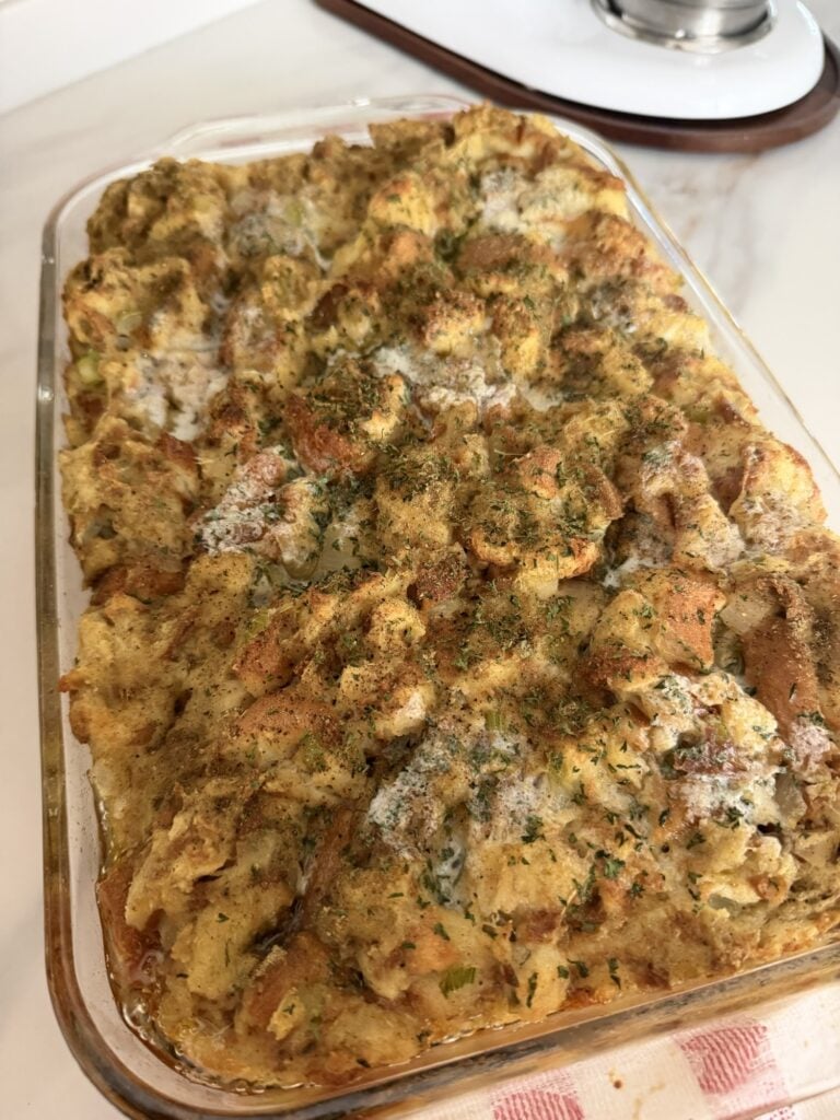 Freshly baked Bell’s Seasoning stuffing puffed and golden brown in a glass casserole dish.