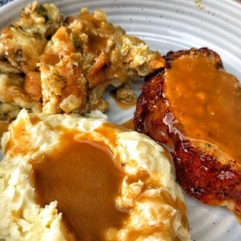 Thanksgiving turkey meatloaf made with ground turkey and stuffing served with mashed potatoes, gravy, and cranberry sauce.