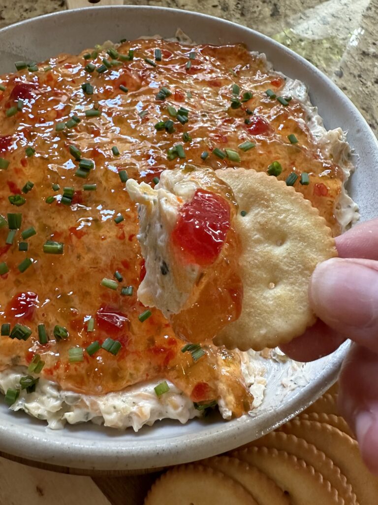 Creamy Pepper Jelly Cheese Dip on a buttery round cracker