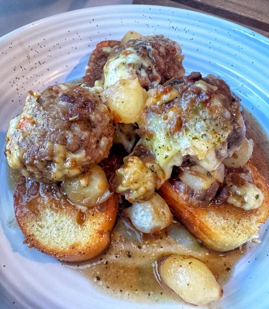 french onion soup meatballs served over toast with cheesed and gravy