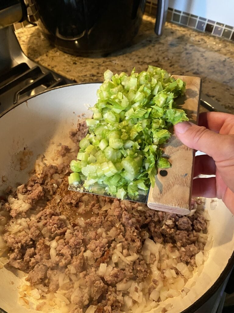 Breakfast sausage cooking with celery onions and mushrooms for Thanksgiving stuffing