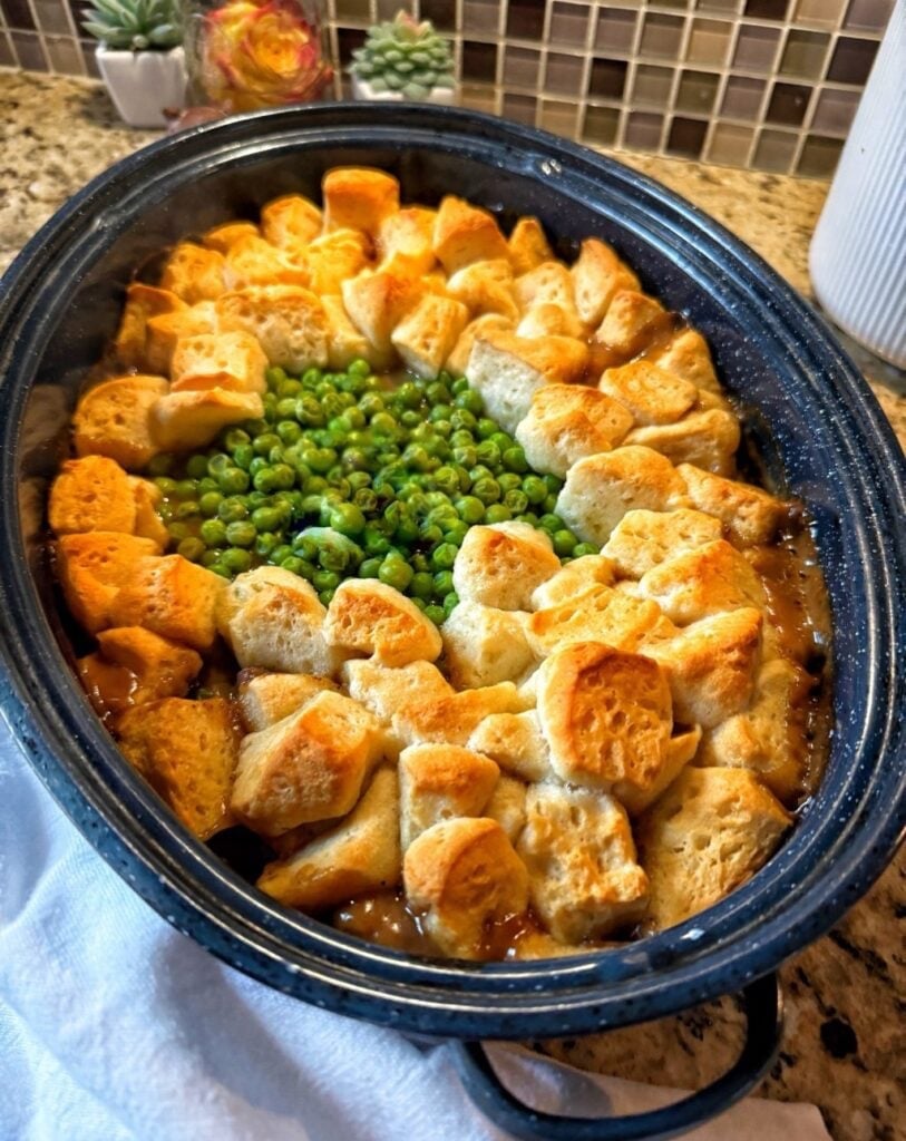 a speckled roaster with peas and dumplings on top