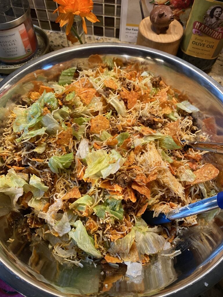 Crushed Doritos and seasoned taco meat over iceberg lettuce for Midwestern Taco Salad