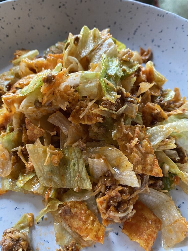 Finished Midwestern Taco Salad with Doritos, seasoned ground beef, cheese, iceberg lettuce, and Western Dressing
