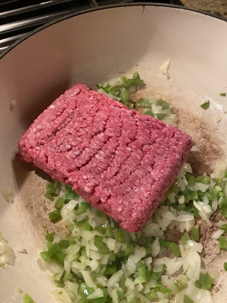 Ground beef and diced onion and pepper cooking in the pan
