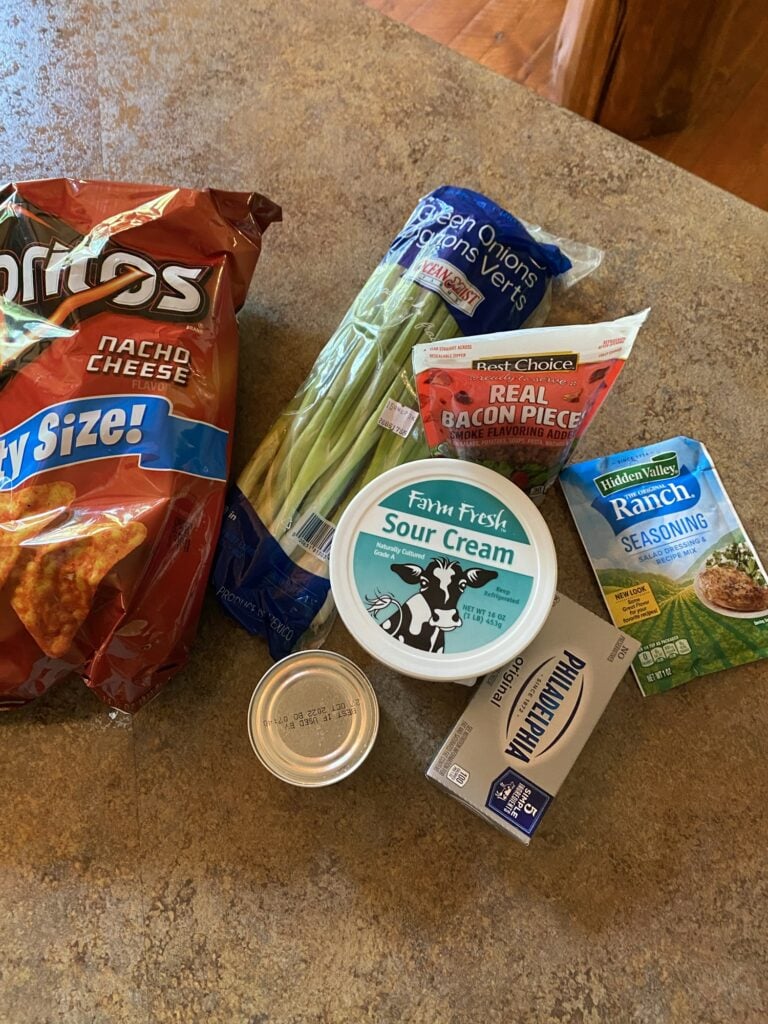 Ingredients for Dorito Chip Dip including cream cheese sour cream ranch bacon and green chiles