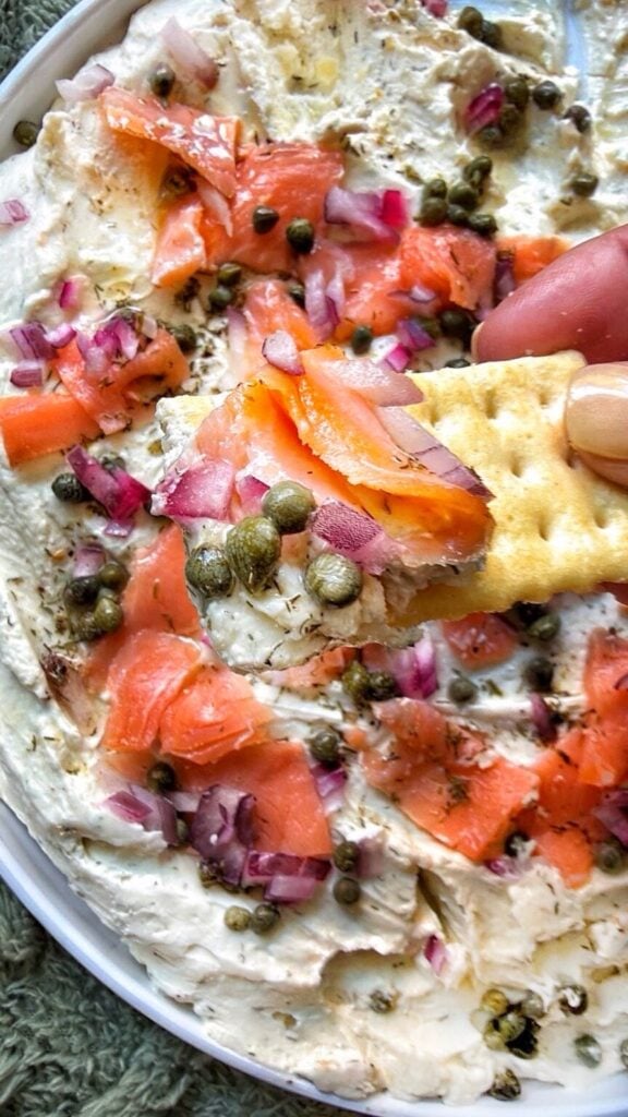 Smoked salmon bagel spread with capers and red onion served on a buttery cracker