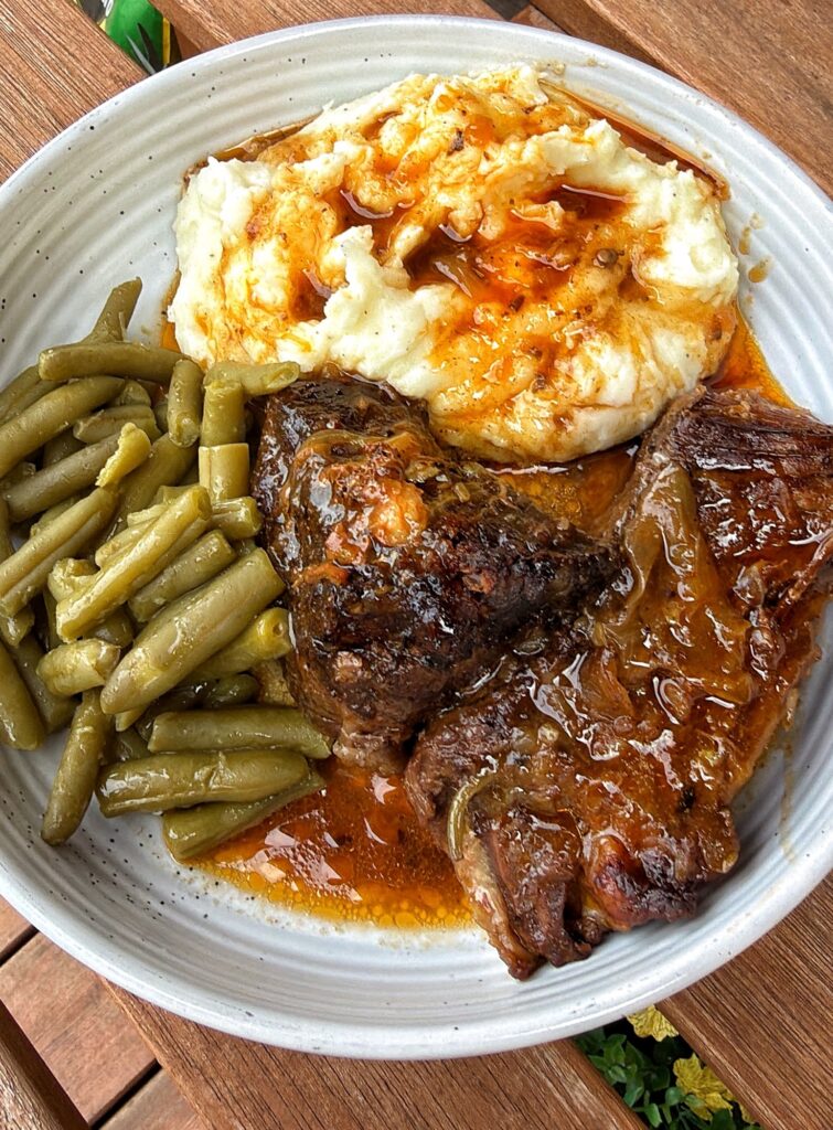Steakhouse Onion Pot Roast served as Sunday dinner with mashed potatoes and green beans
