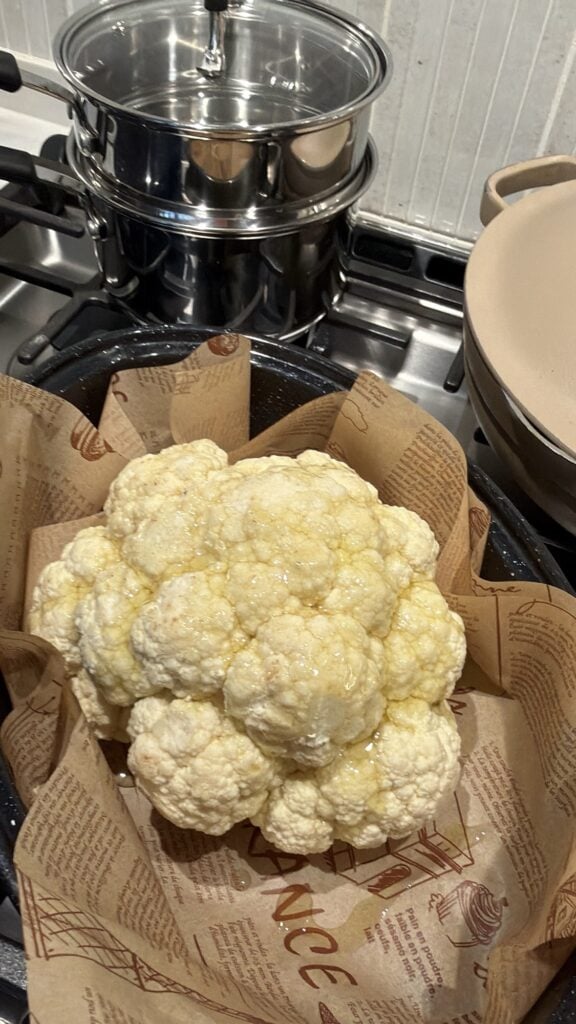 Cleaned whole cauliflower with leaves removed and core intact for roasting.