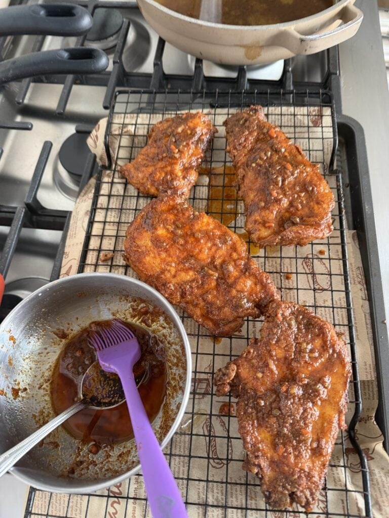 Crispy breaded chicken breasts resting on a wire rack after frying