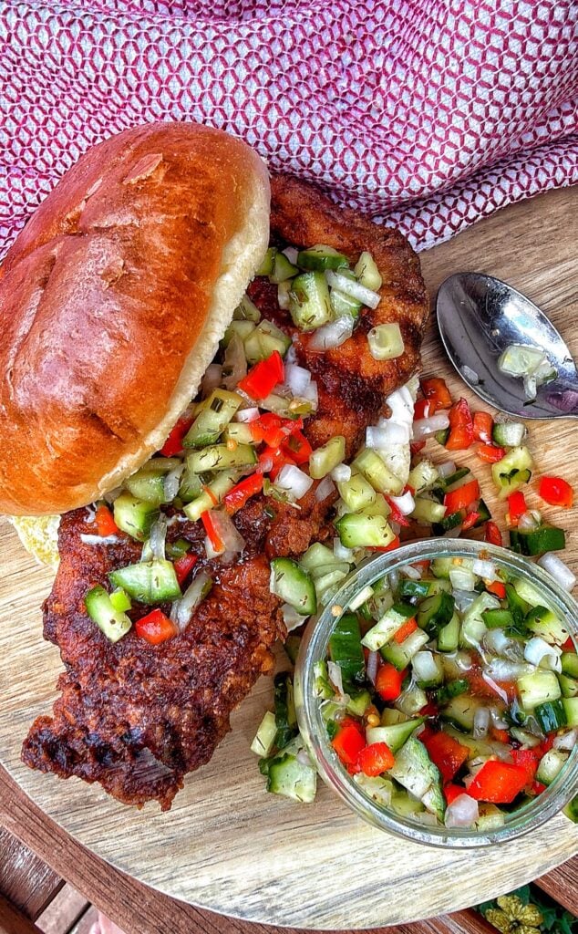 Homemade Chicago hot chicken sandwich on a toasted bun with mayonnaise and cucumber pepper relish on the side