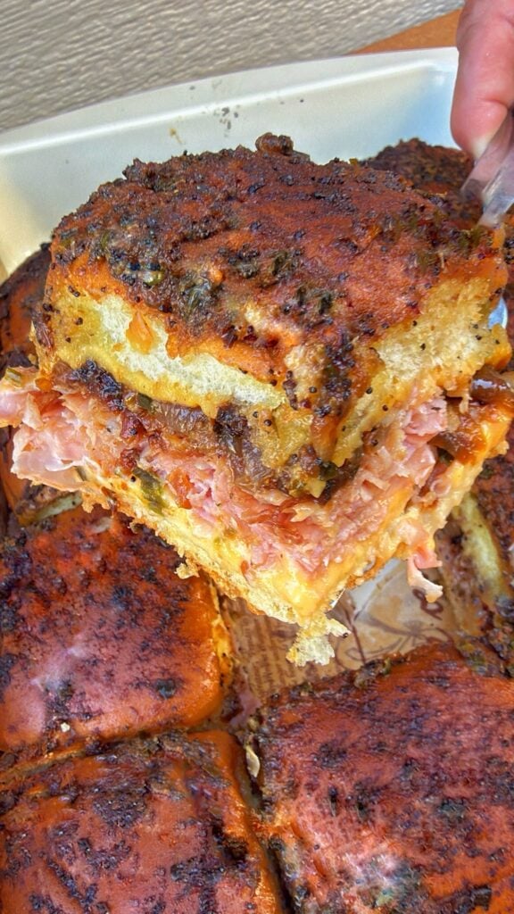 Caramelized Onion Ham and Cheese Sliders pulled apart to show melted American cheese, shaved ham, and sweet Vidalia onions.