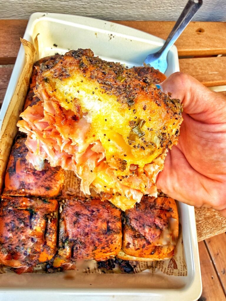 Baked ham and cheese sliders filled with thinly shaved ham, American cheese, and caramelized Vidalia onions.