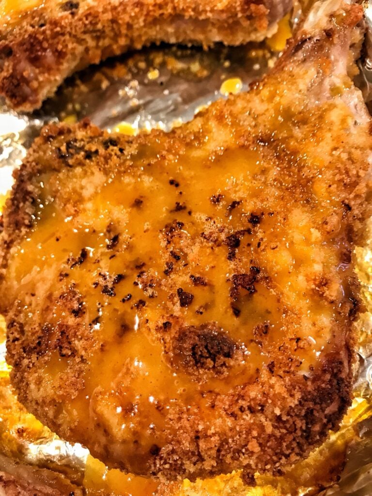 Juicy bone-in pork chop with crispy seasoned coating and honey mustard glaze